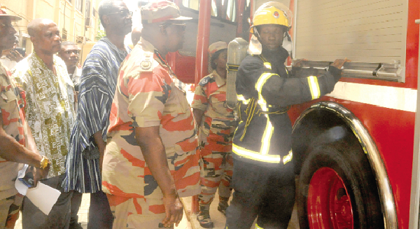 Mr Albert Brown Gaisie (2nd right), the Chief Fire Officer,  Nana Agyekum-Dwamena (2nd left), Head of Civil Service and Mr Samuel Amankwa (left), Director of Research of the Ministry of Interior, inspecting the fire engine after the inauguration